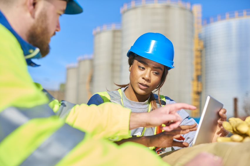 man and woman engineers communicating and pointing to a laptop